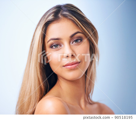 She is beauty personified. Studio shot of a beautiful young woman against a blue background. She is beauty personified. Studio shot of a beautiful young woman against a blue background. 90518195