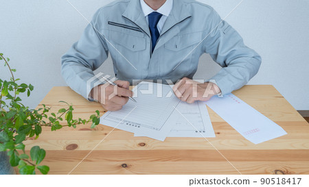 一個穿著工作服的人在寫簡歷│建築相關的求職和求職活動的形象 一個穿著工作服的人在寫簡歷│建築相關的求職和求職活動的形象 90518417