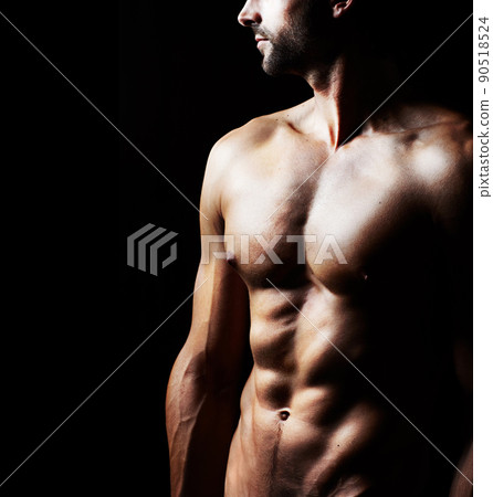 Masculinity in portrait. Studio shot of a muscular shirtless man isolated on black. Masculinity in portrait. Studio shot of a muscular shirtless man isolated on black. 90518524