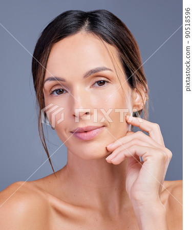 Youll never regret investing in yourself. Shot of a young woman admiring her skin against a studio background. 90518596