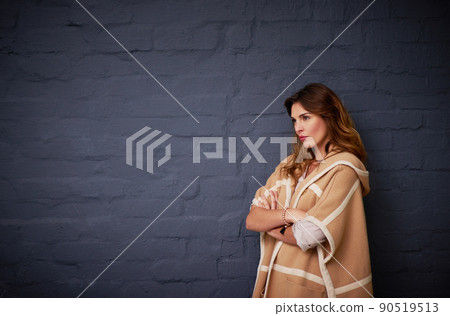 She knows what she wants. Shot of a woman standing against a dark background. 90519513