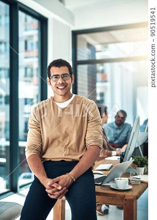 I lead the way for everyone else. Shot of a designer posing in the office with colleagues blurred in the background. I lead the way for everyone else. Shot of a designer posing in the office with colleagues blurred in the background. 90519541