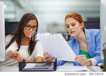When in doubt, ask for advice. Shot of two attractive females looking over some work documents. When in doubt, ask for advice. Shot of two attractive females looking over some work documents. 90519545