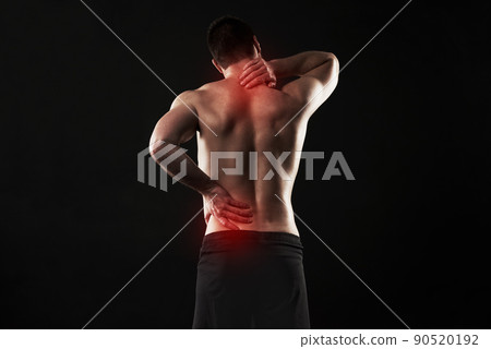I need to get this treated. Studio shot of a sporty young man suffering with back and neck pain isolated on black. I need to get this treated. Studio shot of a sporty young man suffering with back and neck pain isolated on black. 90520192