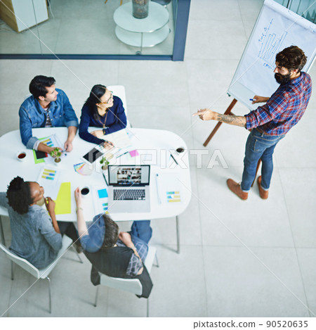 Can you spot the trend. Shot of a young businessman giving a presentation in the boardroom. 90520635