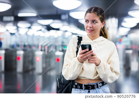 Younh female passing the turnstiles at subway station 90520776