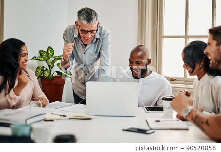 When you finally see your designs online. Shot of a group of businesspeople cheering while using a laptop during a meeting in a modern office. 90520858