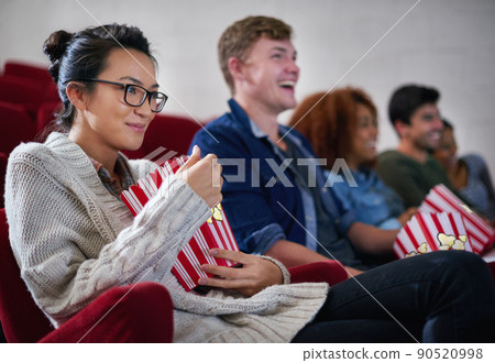 Hanging with friends at the cinema. Shot of friends enjoying watching a movie in a cinema. Hanging with friends at the cinema. Shot of friends enjoying watching a movie in a cinema. 90520998
