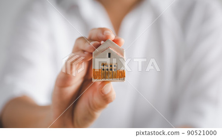 woman holding home model on hand 90521000