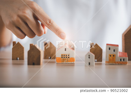 closeup woman finger pointing on beautiful home model closeup woman finger pointing on beautiful home model 90521002