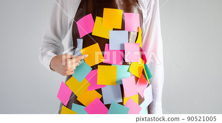 closeup woman wears apron with colorful sticky note paper closeup woman wears apron with colorful sticky note paper 90521005