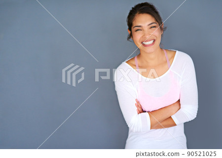 Motivate yourself or no one will. Cropped shot of a sporty young woman standing with her arms folded against a grey background. 90521025