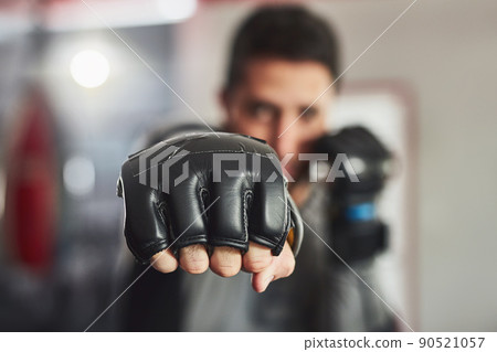 Coming at you full force. Cropped portrait of a professional fighter training in the gym. Coming at you full force. Cropped portrait of a professional fighter training in the gym. 90521057
