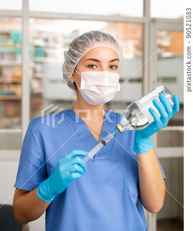 Female nurse or doctor wearing in face mask and medical uniform Female nurse or doctor wearing in face mask and medical uniform 90521083