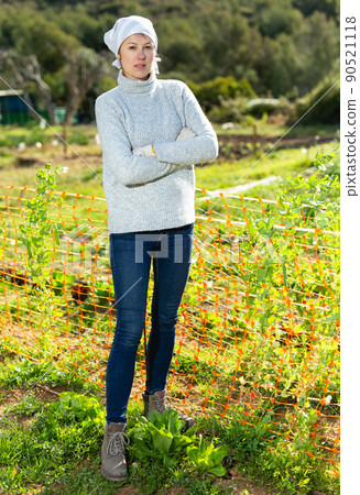Female gardener standing in homestead Female gardener standing in homestead 90521118