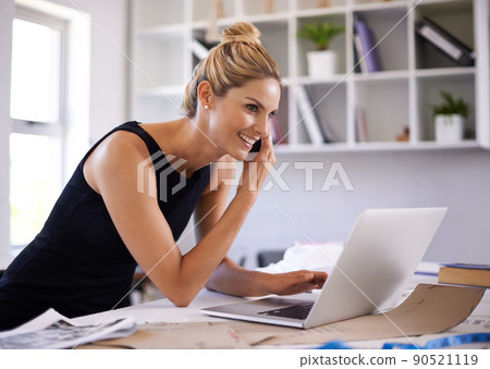 Keeping her clients up to date. A beautiful young businesswoman speaking on the phone while working on her laptop. Keeping her clients up to date. A beautiful young businesswoman speaking on the phone while working on her laptop. 90521119