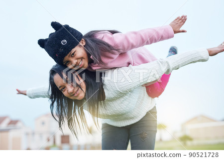 Again, again mommy. Shot of a mother and daughter playing a game outside. Again, again mommy. Shot of a mother and daughter playing a game outside. 90521728