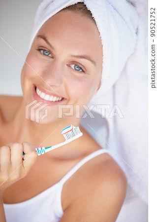 Maintaining the perfect smile. Shot of a beautiful woman brushing her teeth. Maintaining the perfect smile. Shot of a beautiful woman brushing her teeth. 90521752