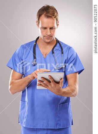 Technological treatment. Studio shot of a handsome male doctor using a digital tablet. Technological treatment. Studio shot of a handsome male doctor using a digital tablet. 90522075