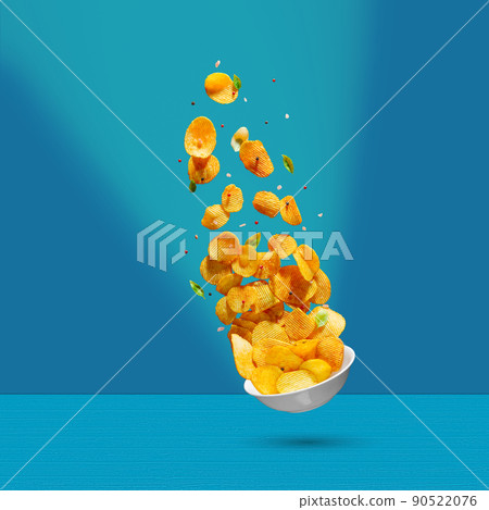 Potato chips falling onto plate on white background. Advertising concept. Levitation flying chips Potato chips falling onto plate on white background. Advertising concept. Levitation flying chips 90522076
