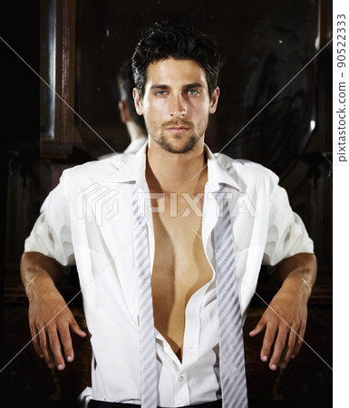 Just you and me. A handsome young man leaning on a bar counter with his shirt slightly open. Just you and me. A handsome young man leaning on a bar counter with his shirt slightly open. 90522333