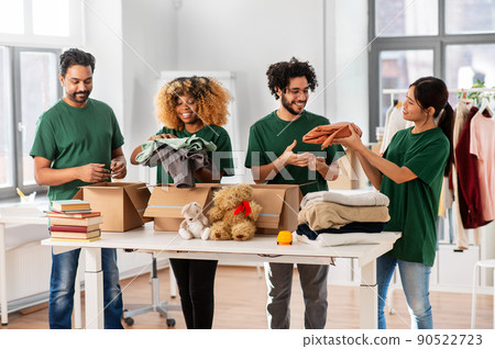 happy volunteers packing stuff in donation boxes happy volunteers packing stuff in donation boxes 90522723