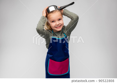 happy little girl in apron playing with saucepan 90522808