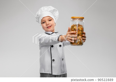 girl in chef's toque holding glass jar with pasta 90522889