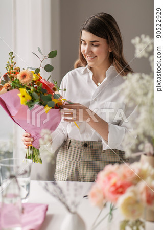 happy woman with bunch of flowers at home 90522929