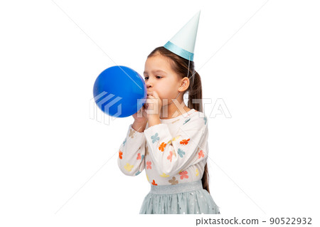 little girl in birthday party hat blowing balloon little girl in birthday party hat blowing balloon 90522932
