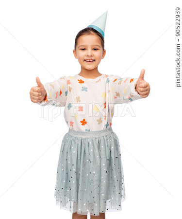 happy girl in birthday party hat showing thumbs up happy girl in birthday party hat showing thumbs up 90522939