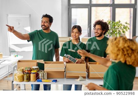 happy volunteers packing food in donation boxes happy volunteers packing food in donation boxes 90522998