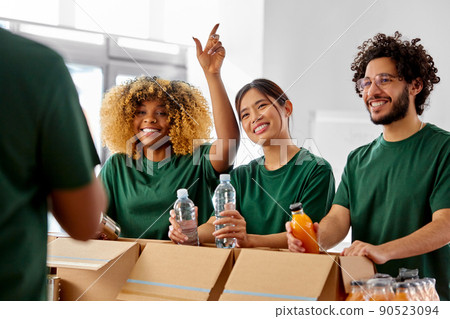 happy volunteers packing food in donation boxes 90523094