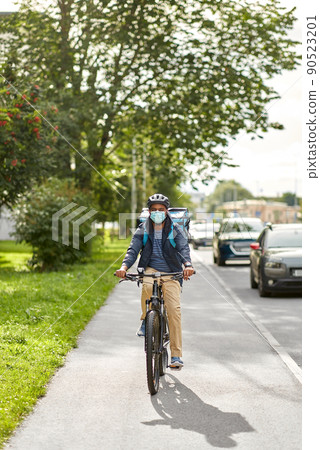 food delivery man in mask with bag riding bicycle food delivery man in mask with bag riding bicycle 90523201