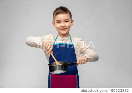 little boy in apron with saucepan cooking food 90523252