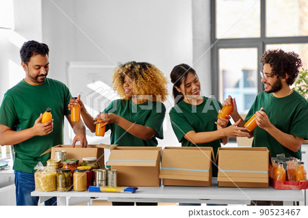 happy volunteers packing food in donation boxes 90523467