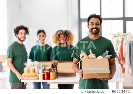 happy volunteers packing food in donation boxes happy volunteers packing food in donation boxes 90523472