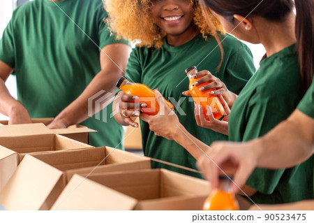close up of volunteers packing food in boxes close up of volunteers packing food in boxes 90523475