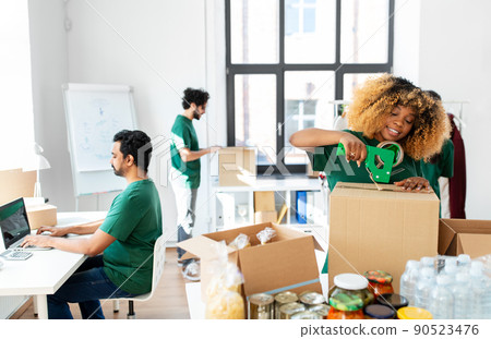 happy volunteers packing food in donation boxes 90523476