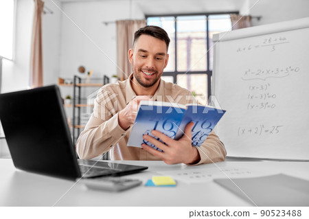 math teacher with laptop and book at home office 90523488