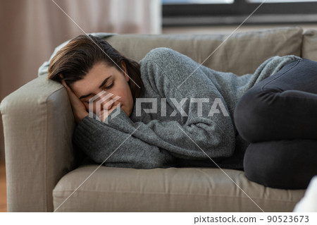 depressed woman lying on sofa at home 90523673