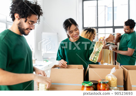 happy volunteers packing food in donation boxes 90523693