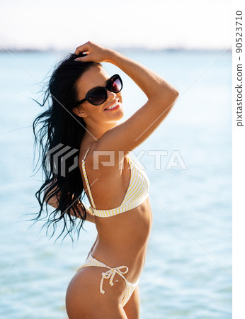 smiling young woman in bikini swimsuit on beach smiling young woman in bikini swimsuit on beach 90523710