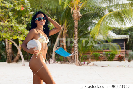 woman in bikini posing with volleyball on beach woman in bikini posing with volleyball on beach 90523902