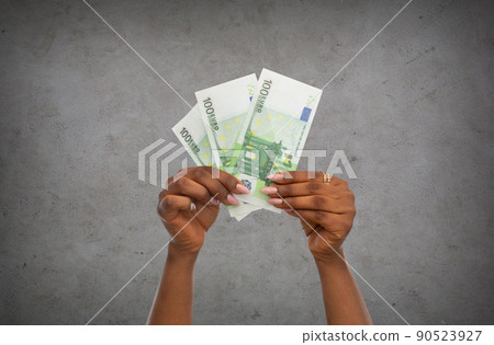 close up of hands holding euro money over grey 90523927