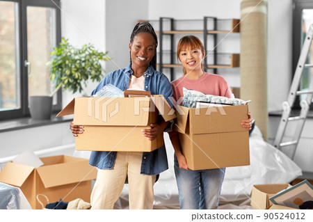 women with boxes moving to new home 90524012