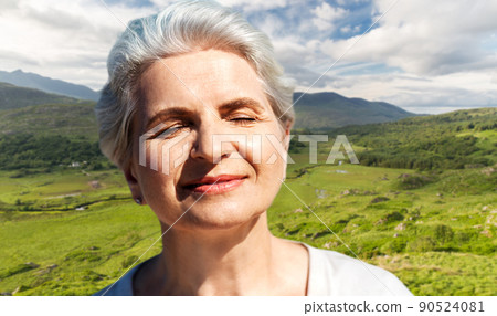 portrait of senior woman enjoying sun on beach 90524081
