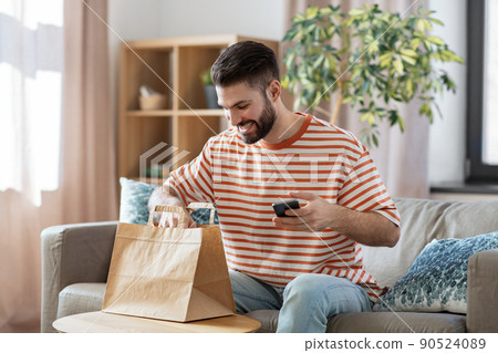 man with phone checking food order at home 90524089