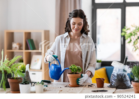happy woman planting pot flowers at home happy woman planting pot flowers at home 90524241
