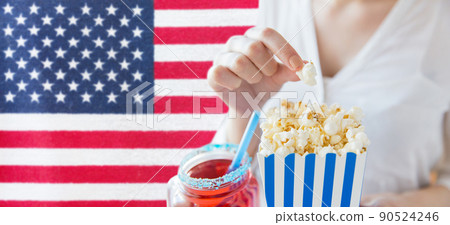 woman eating popcorn at 4th july party woman eating popcorn at 4th july party 90524246